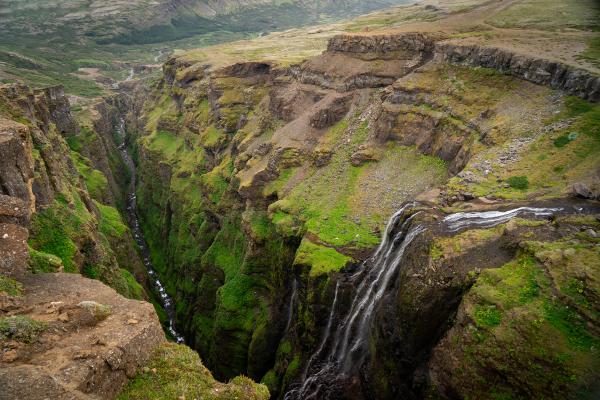 there is a waterfall in the middle of a canyon .