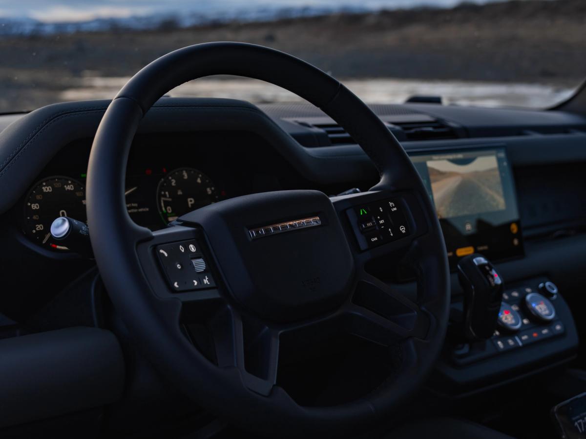 Volante del Defender Interior de un Land Rover Defender en el que se ven el volante, el cuadro de instrumentos y la pantalla táctil
