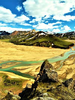 a river runs through a valley surrounded by mountains .