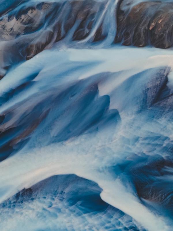 an aerial view of a river flowing through a rocky landscape in the highlands in iceland.