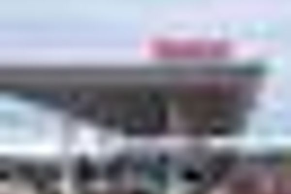 a blurry picture of a large building with a red sign on top of it .