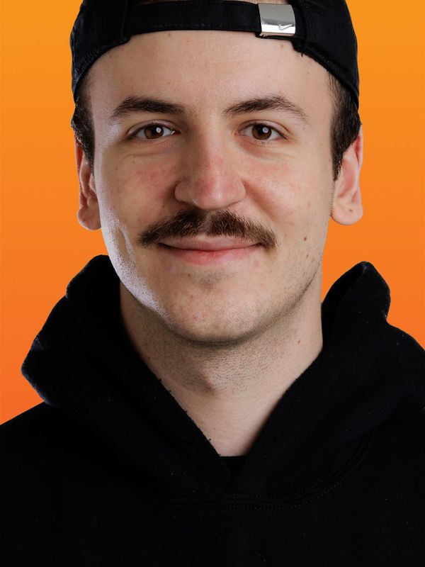 a man wearing a black hat and a black shirt with the letter g on it