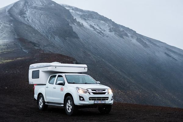 White 4x4 campervan with an extra tent attached to it