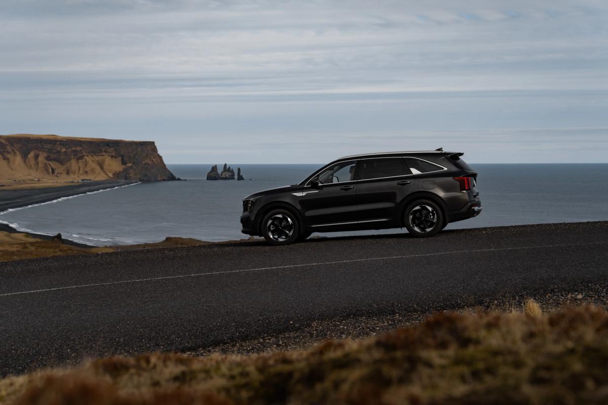 Kia Sorento vue de profil sur une route côtière, avec des stacks et des falaises en arrière-plan