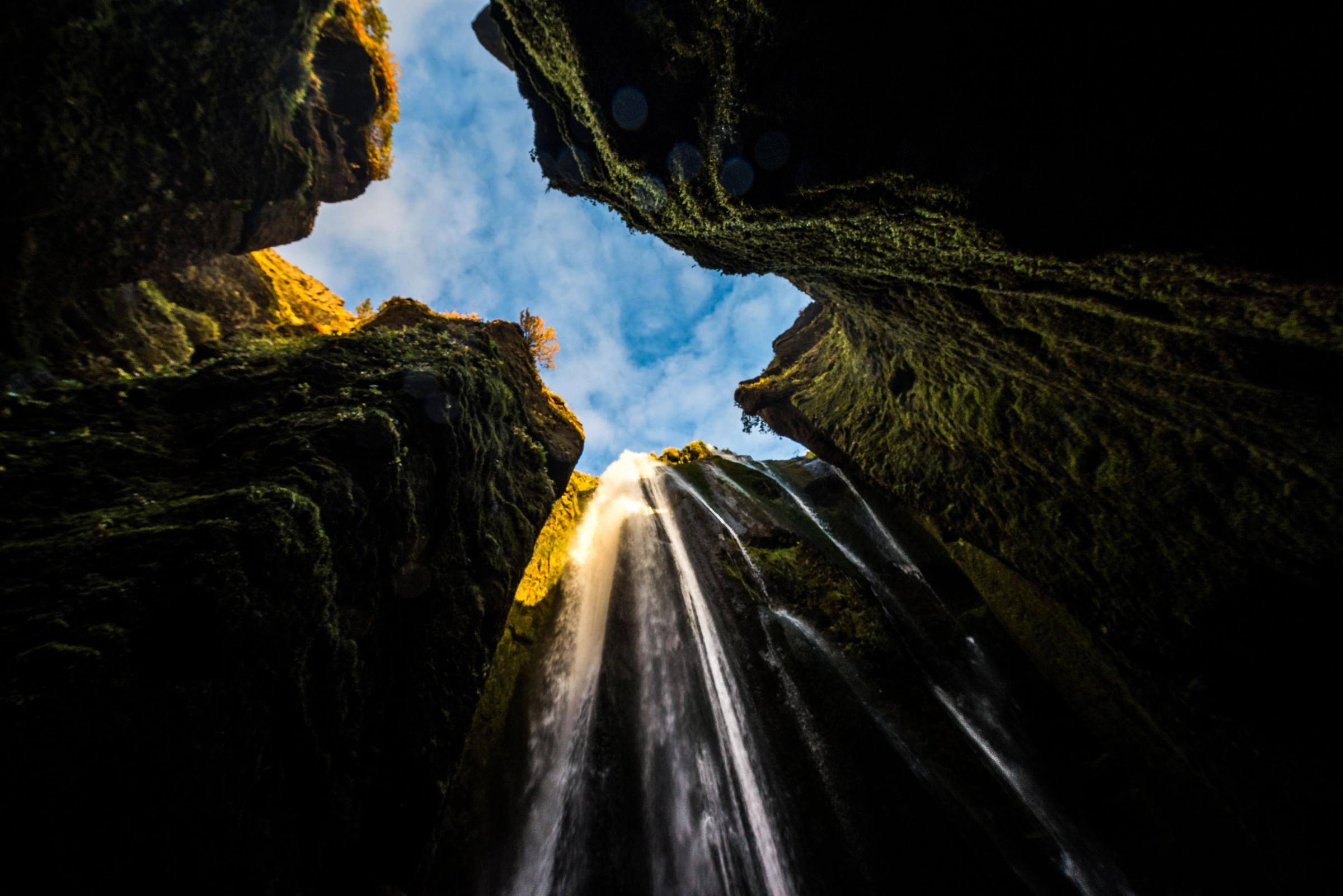mirando hacia arriba a una cascada en medio de un cañón .