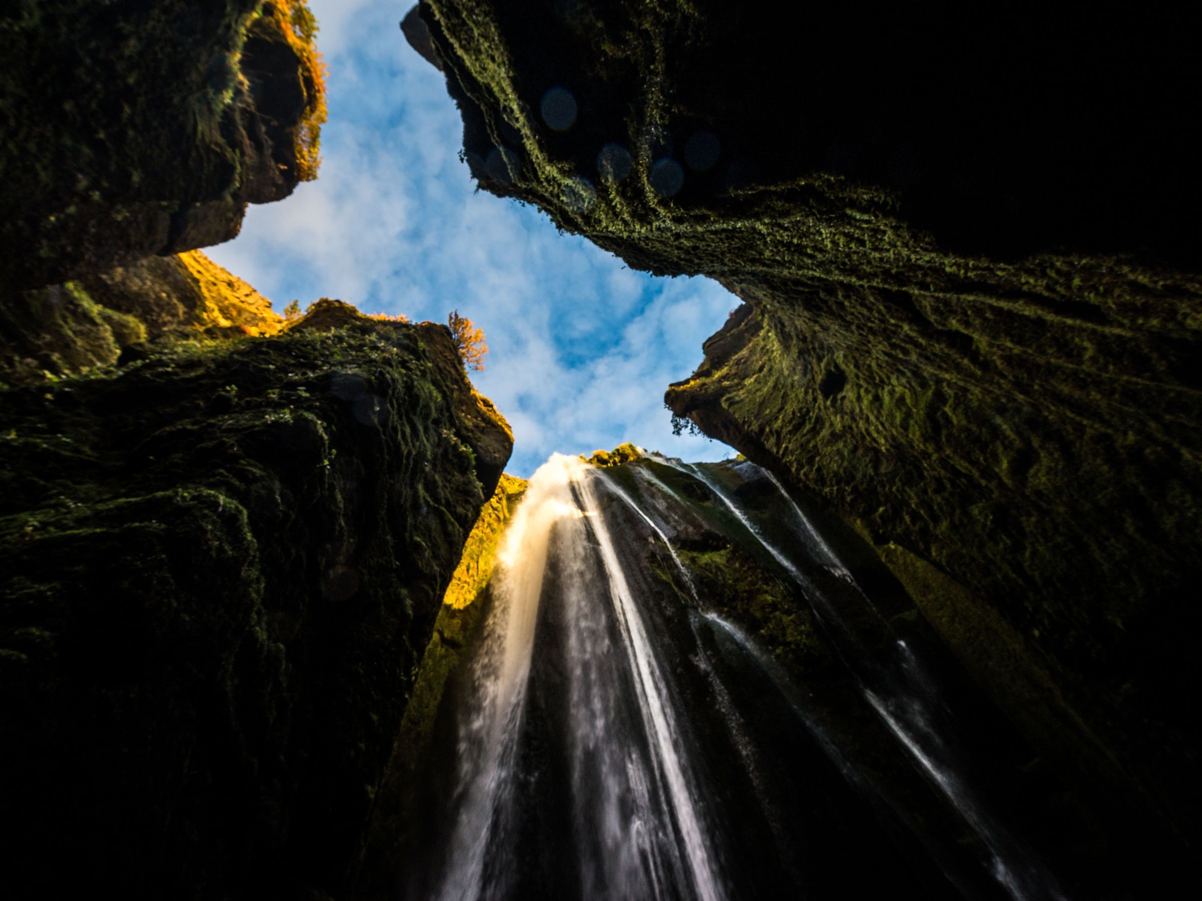 mirando hacia arriba a una cascada en medio de un cañón .