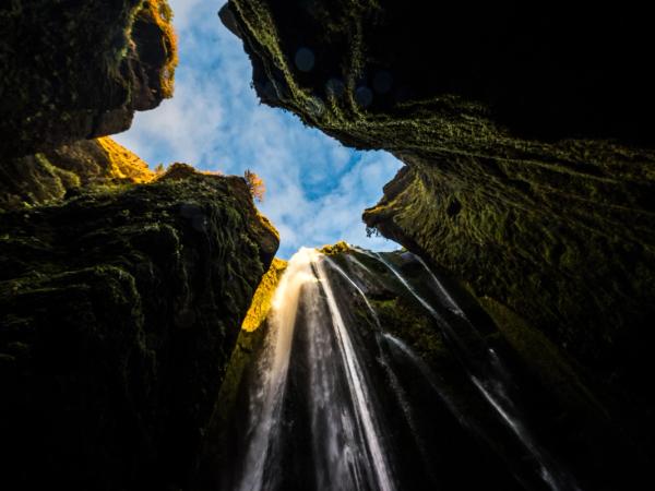 mirando hacia arriba a una cascada en medio de un cañón .