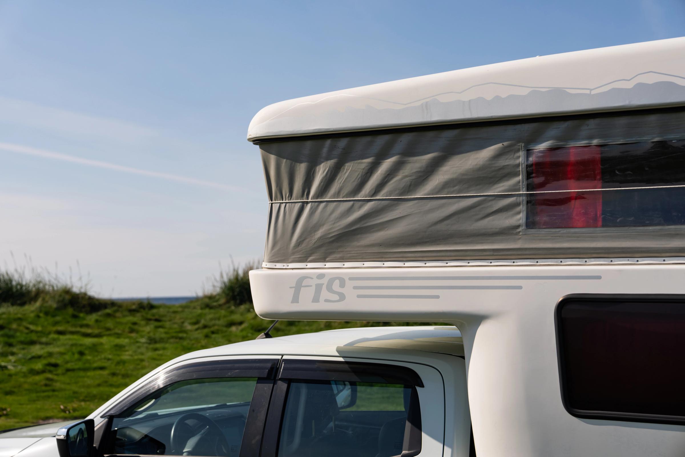 Pop-Up Roof Side Detail Close-up of the raised pop-up roof with fabric sides and a window above the cab