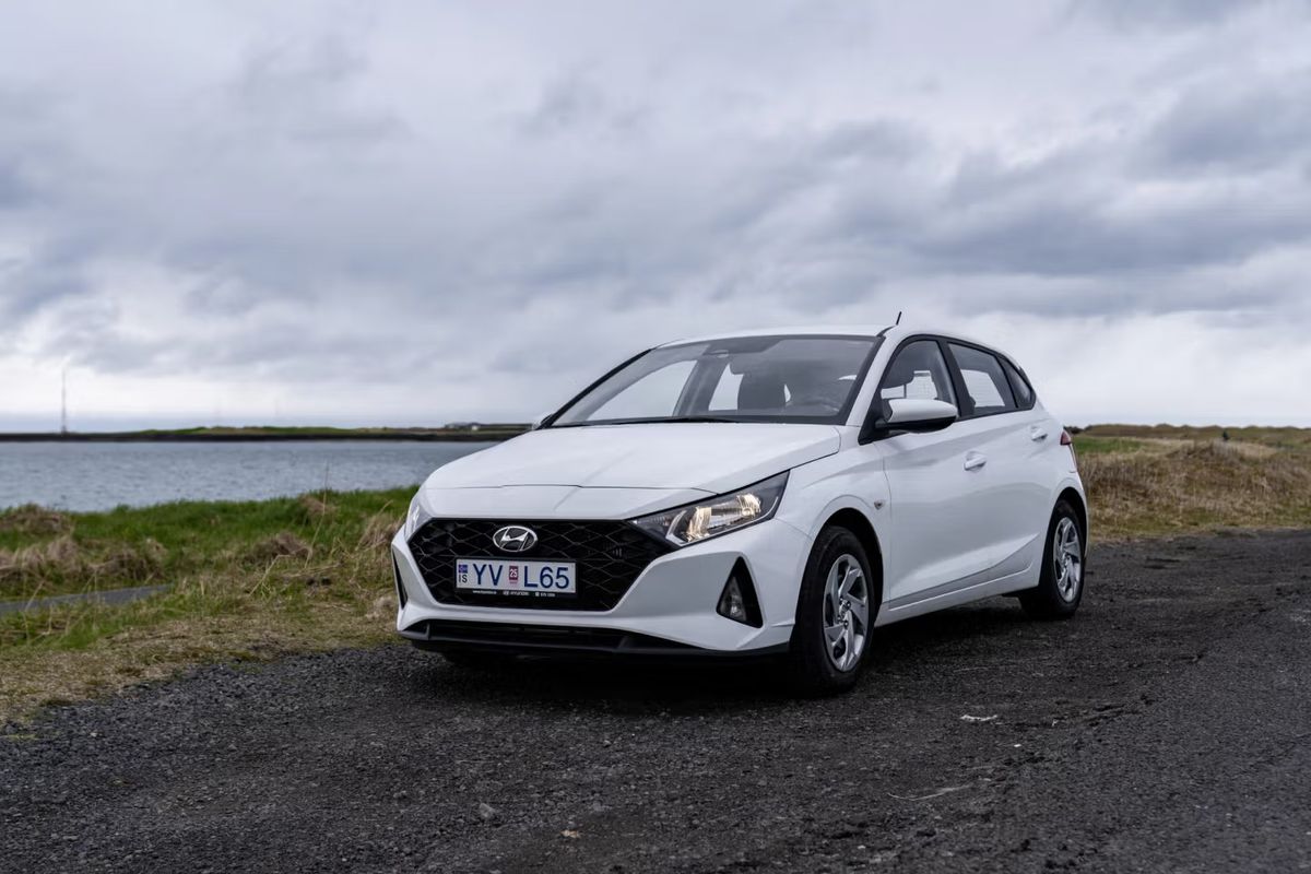 Hyundai i20 blanco aparcado en una carretera con un lago detrás