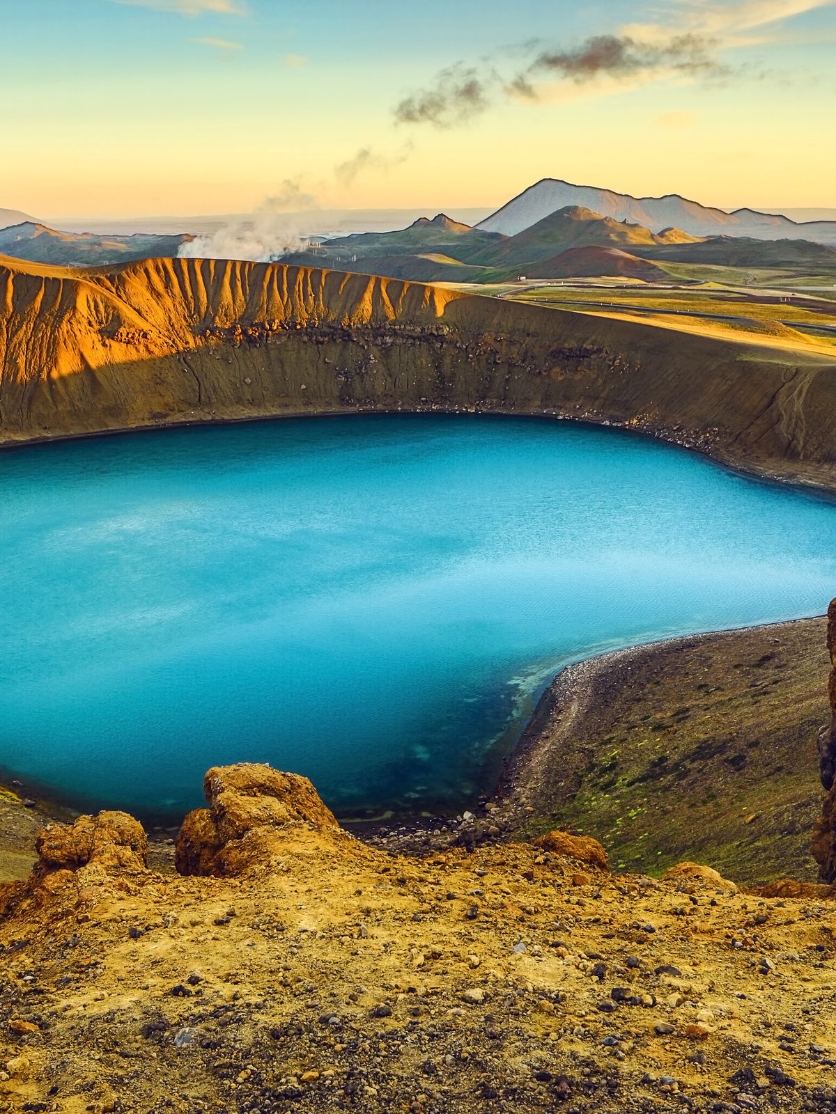 un gran lago azul en medio de una montaña rodeada de rocas.