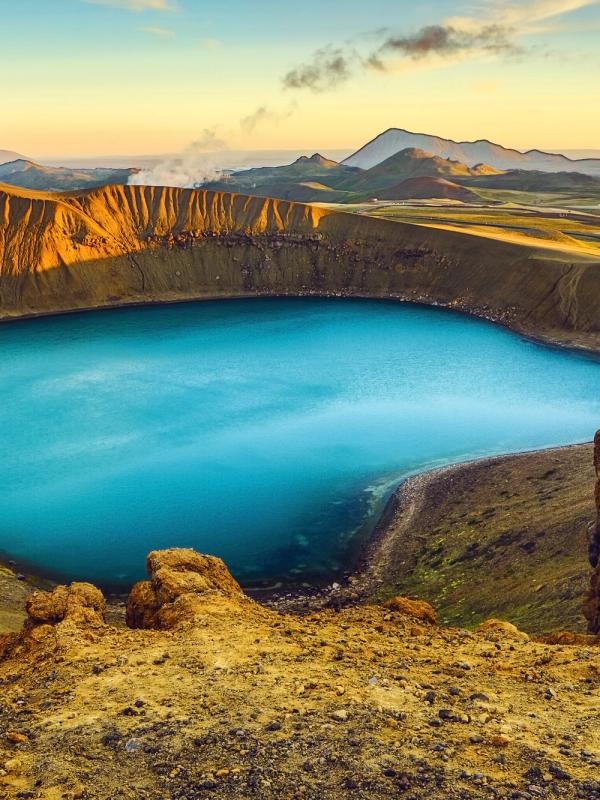 un gran lago azul en medio de una montaña rodeada de rocas.