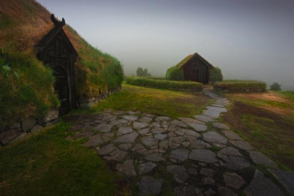 there is a stone path leading to a house with a thatched roof .