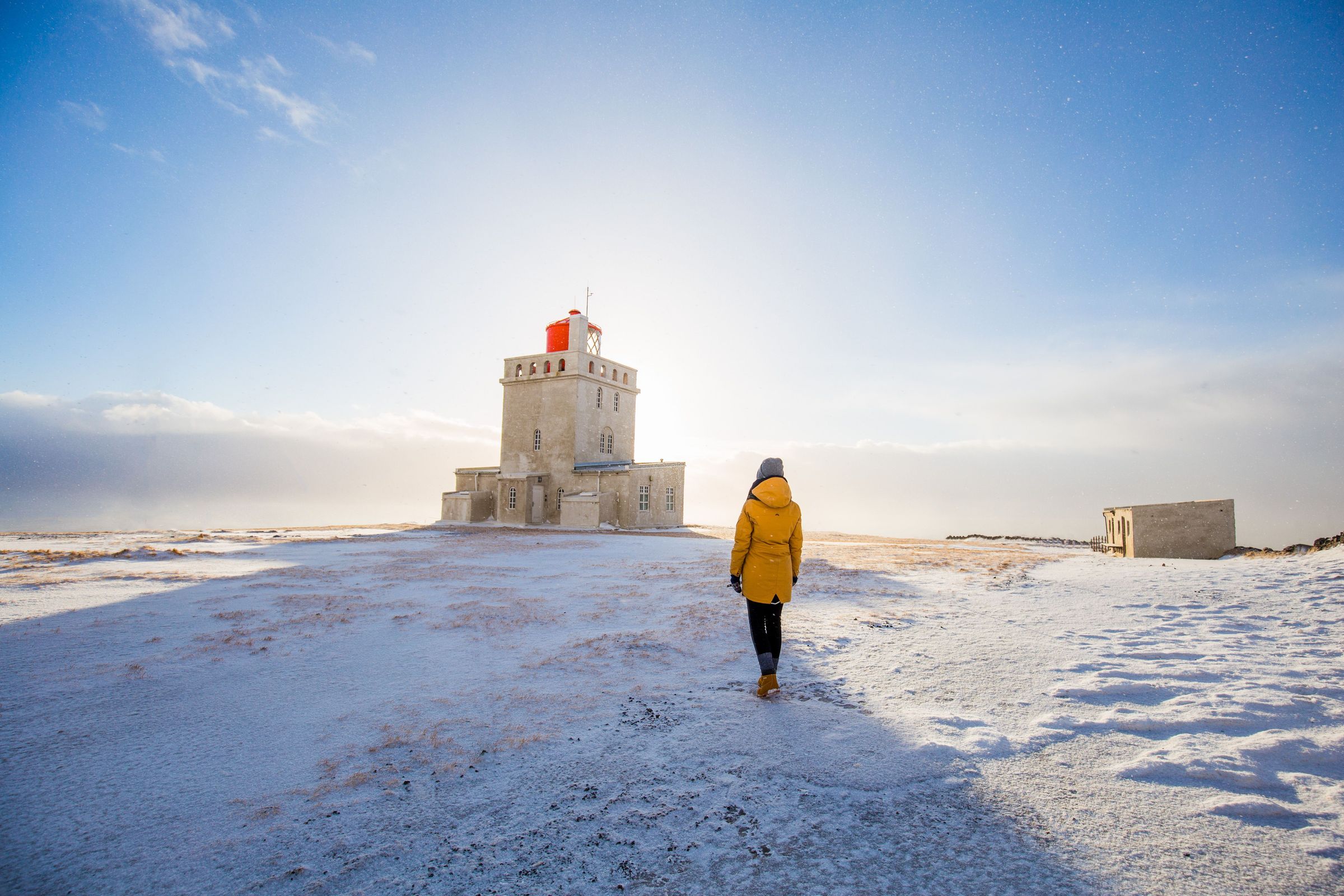 Mujer admirando el faro de Dyrhólaey
