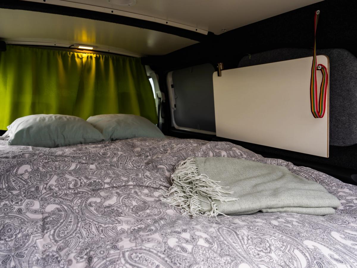 Cortina de privacidad cerrada Cama con la cortina de privacidad cerrada delante de la cabina y la luz del techo encendida