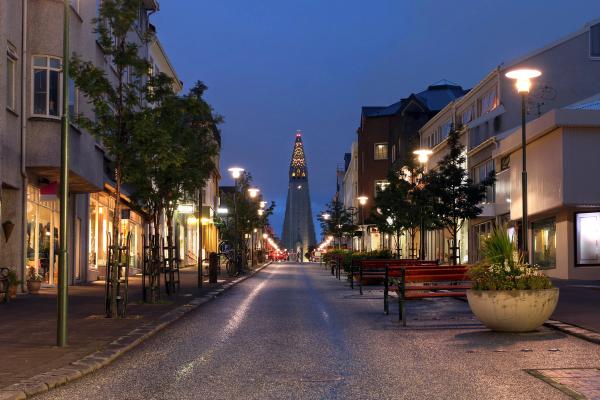 a city street at night with a very tall building in the background .