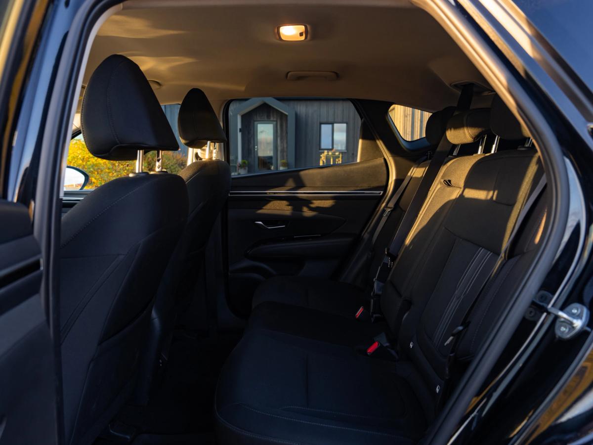 Rangée de sièges arrière du Tucson Espace aux jambes à l’arrière et sièges en tissu du Hyundai Tucson, vus à travers la portière arrière ouverte