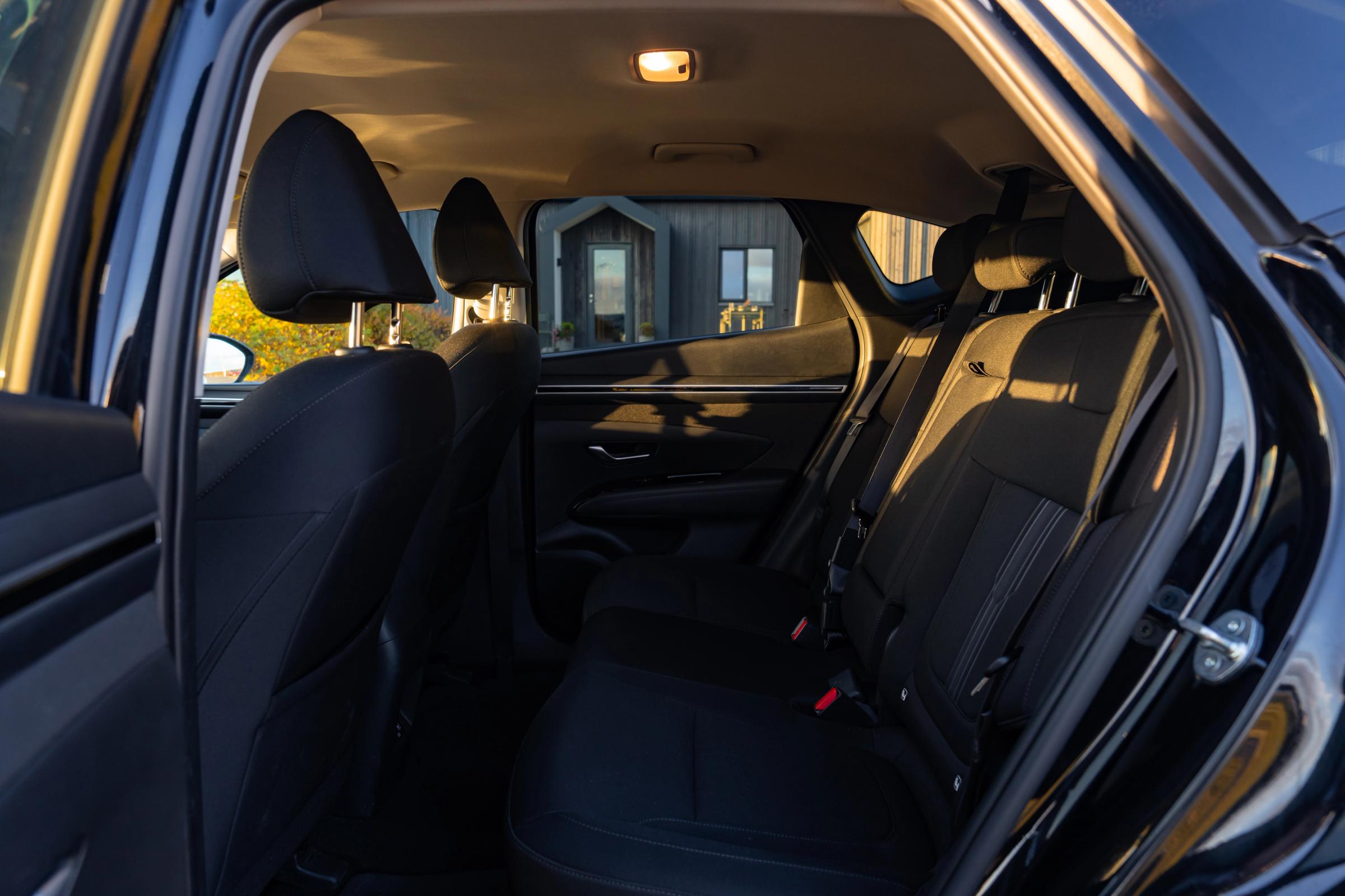 Rangée de sièges arrière du Tucson Espace aux jambes à l’arrière et sièges en tissu du Hyundai Tucson, vus à travers la portière arrière ouverte