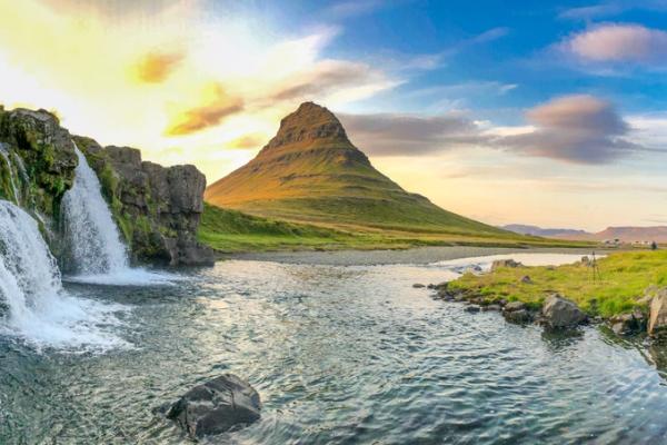 there is a waterfall and a mountain in the background .