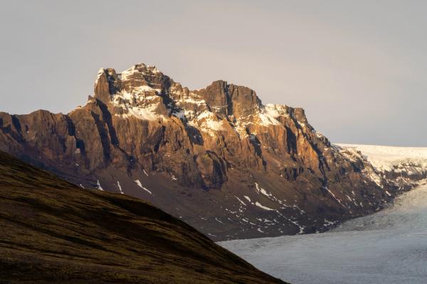 une montagne couverte de neige et de glace avec un glacier au premier plan.