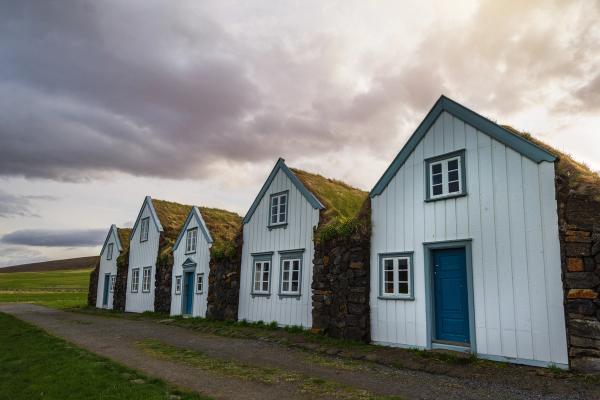 Cuatro casas de turba blancas y azules con césped en el techo