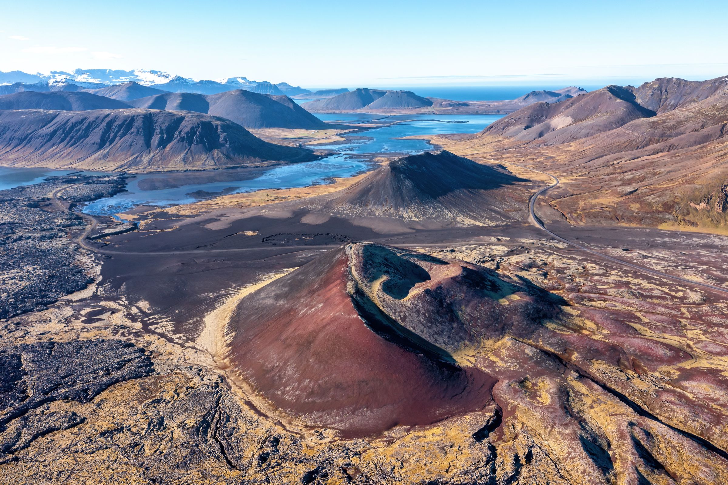 an aerial view of a volcano with mountains in the background .