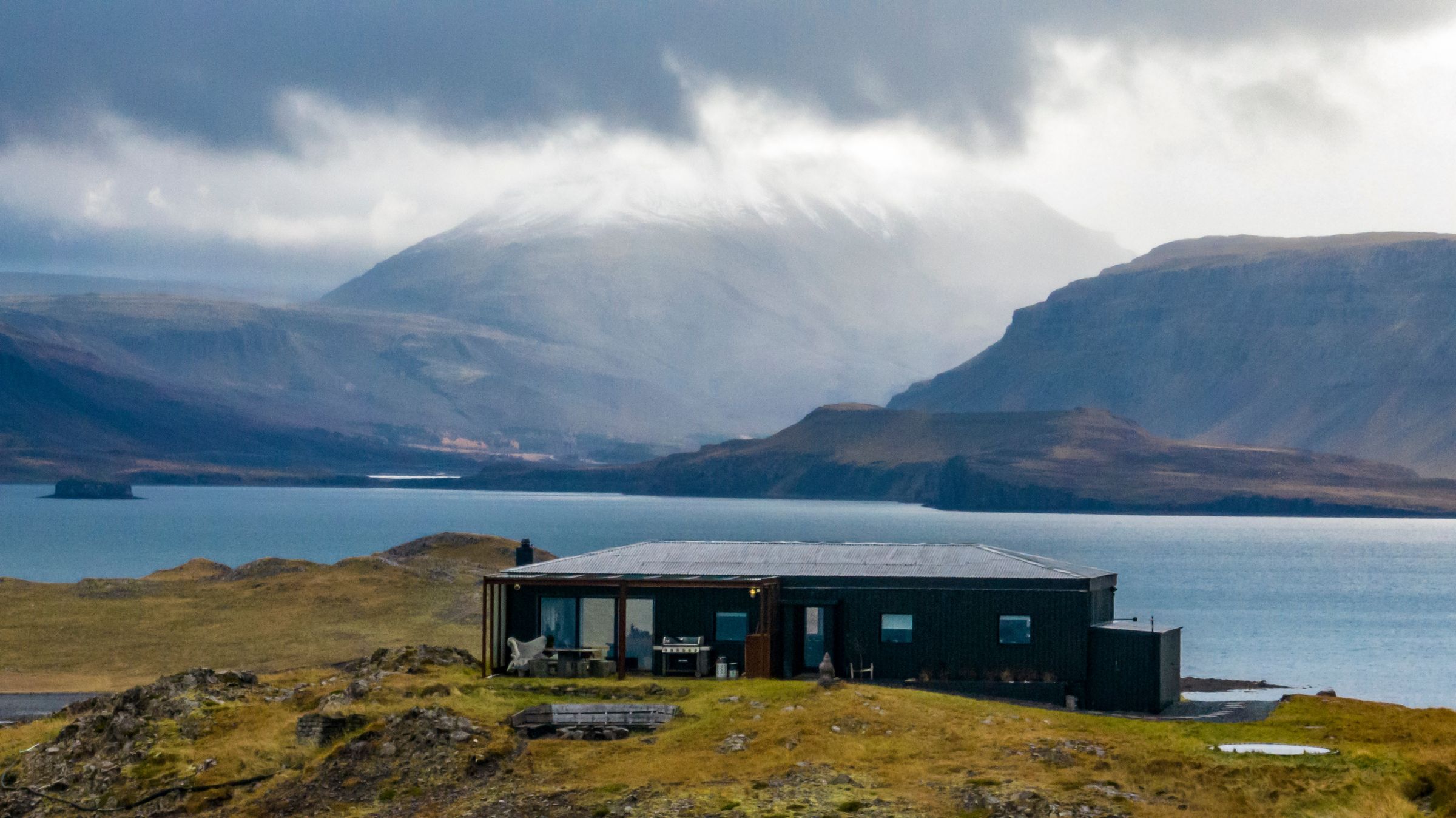 panoramic of a fiord with a house on the foreground