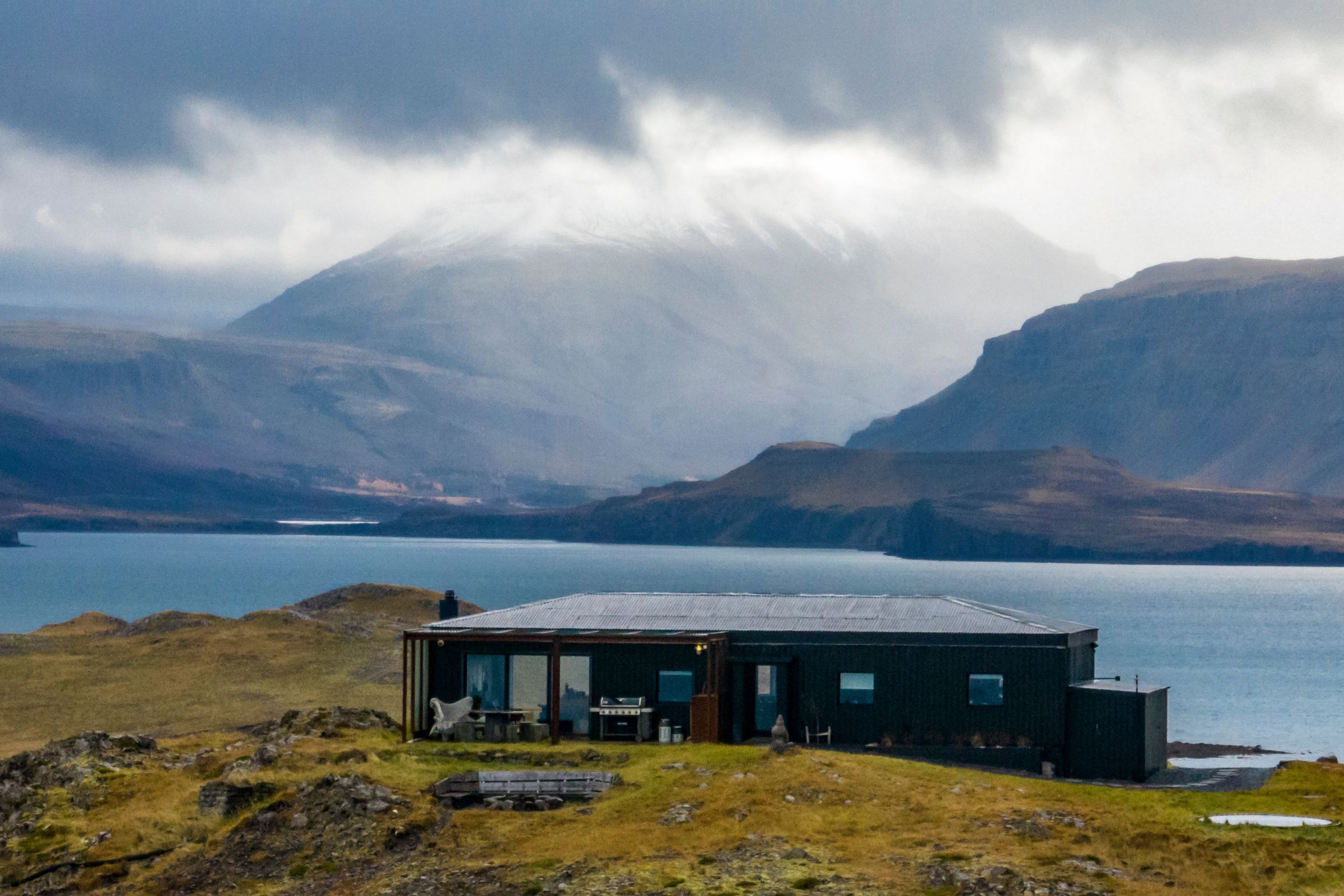 panoramic of a fiord with a house on the foreground