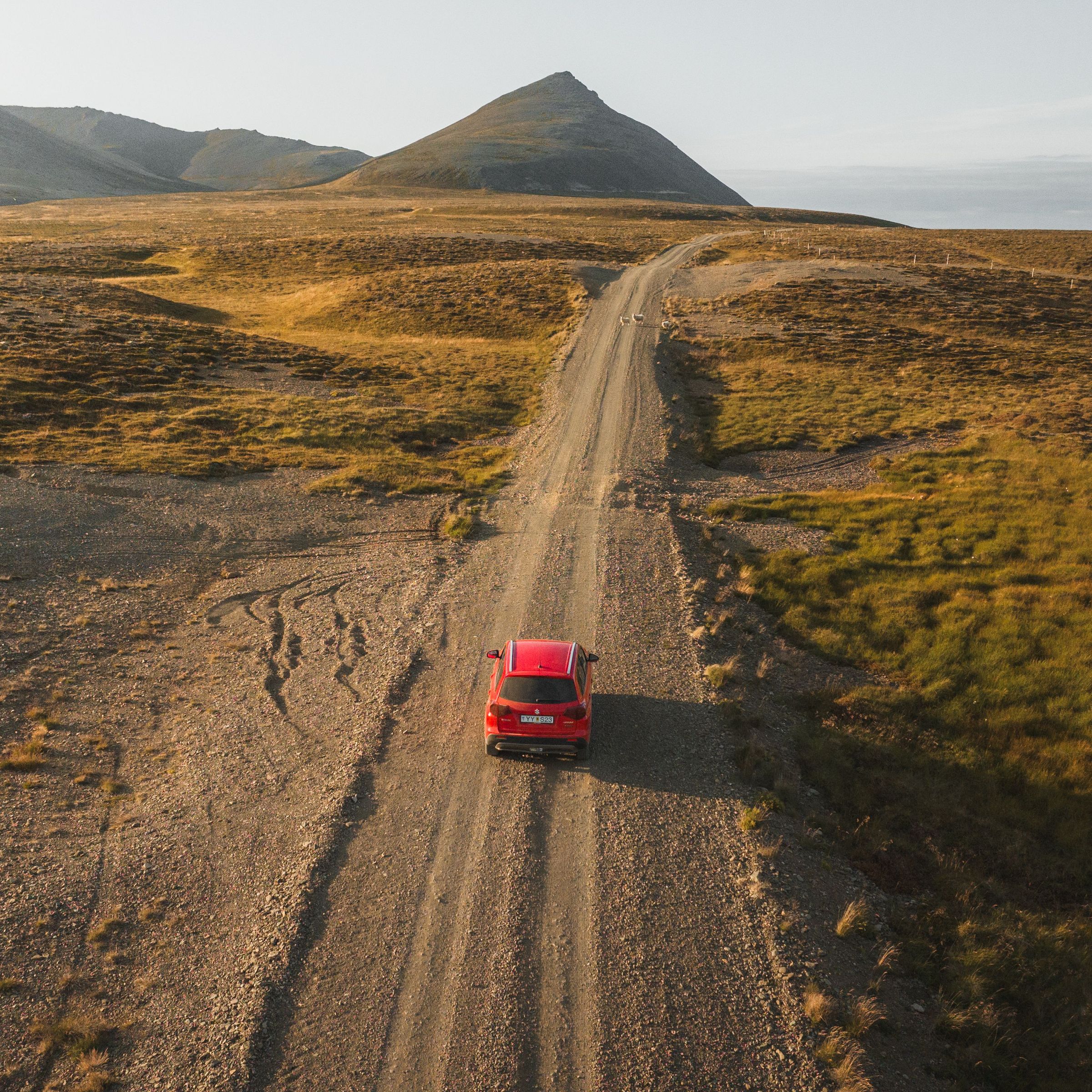 Red car on a gravel road in Iceland