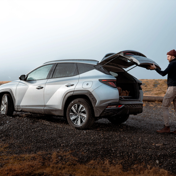 Chico cerrando el maletero de su coche en Islandia