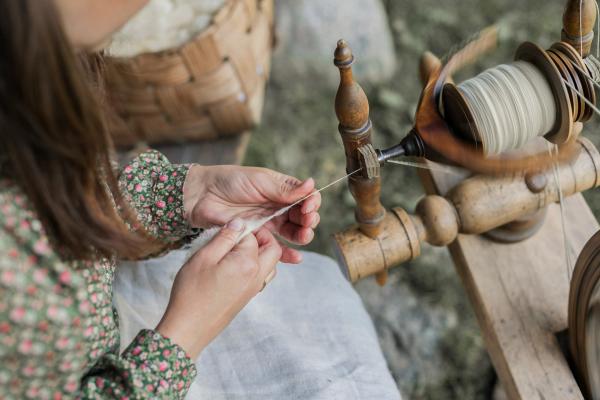 las manos de una mujer hilando lana de manera tradicional