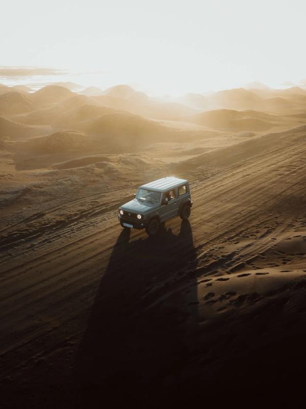 Coche conduciendo hacia unas montañas nevadas en Islandia
