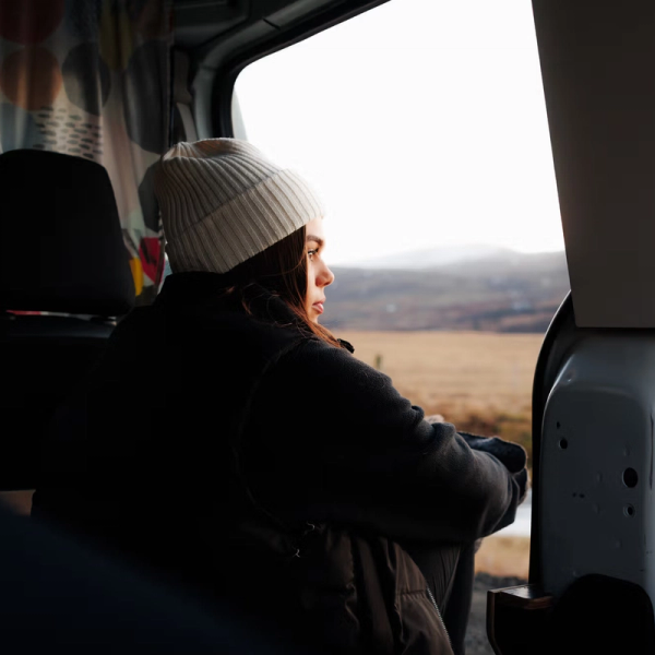 une femme portant un bonnet blanc regarde par la fenêtre d'une voiture