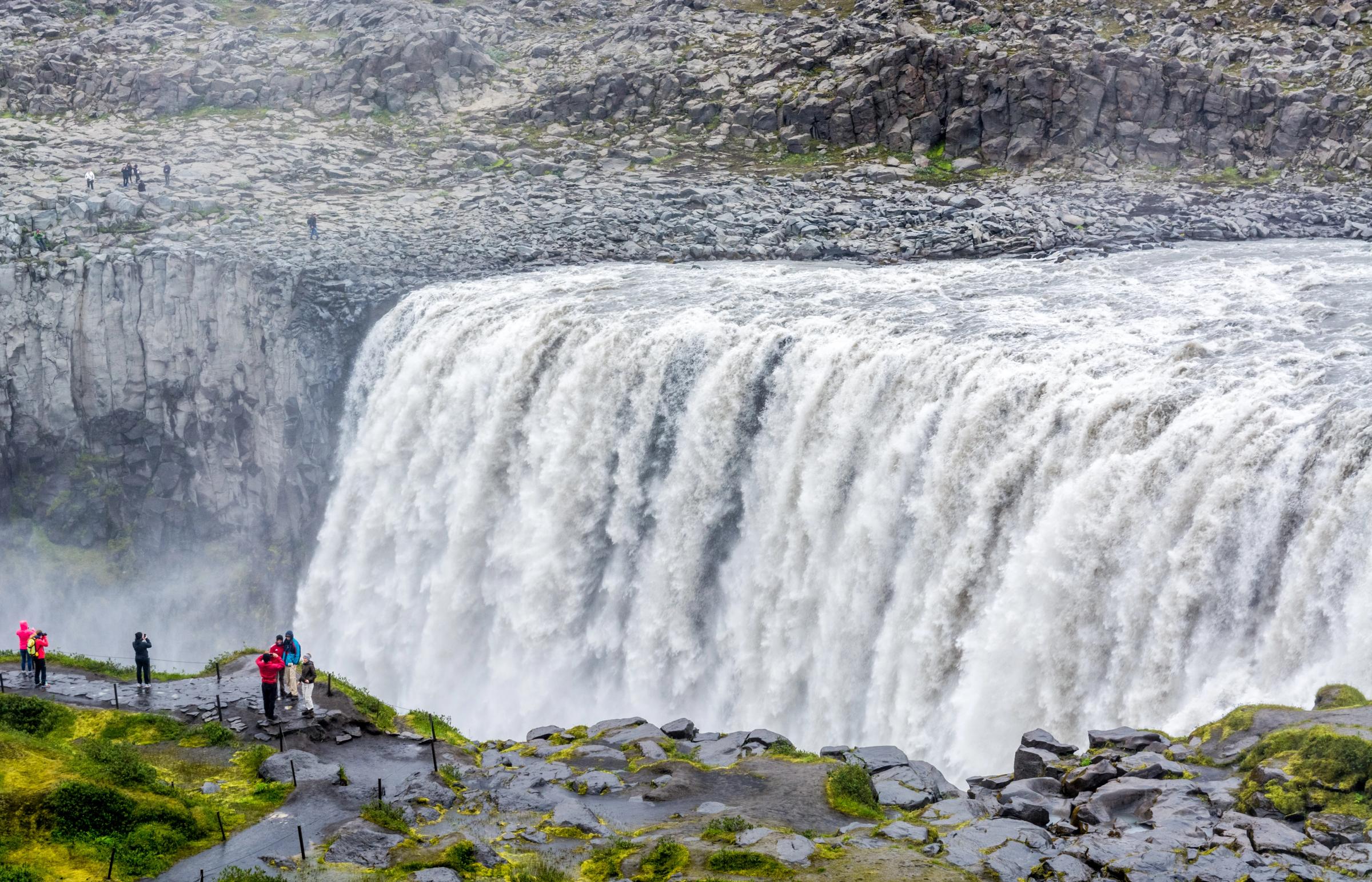 un grupo de personas está parado al borde de una cascada.
