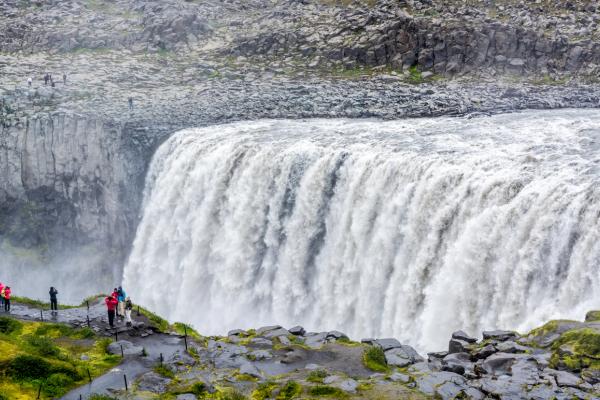 un grupo de personas está parado al borde de una cascada.