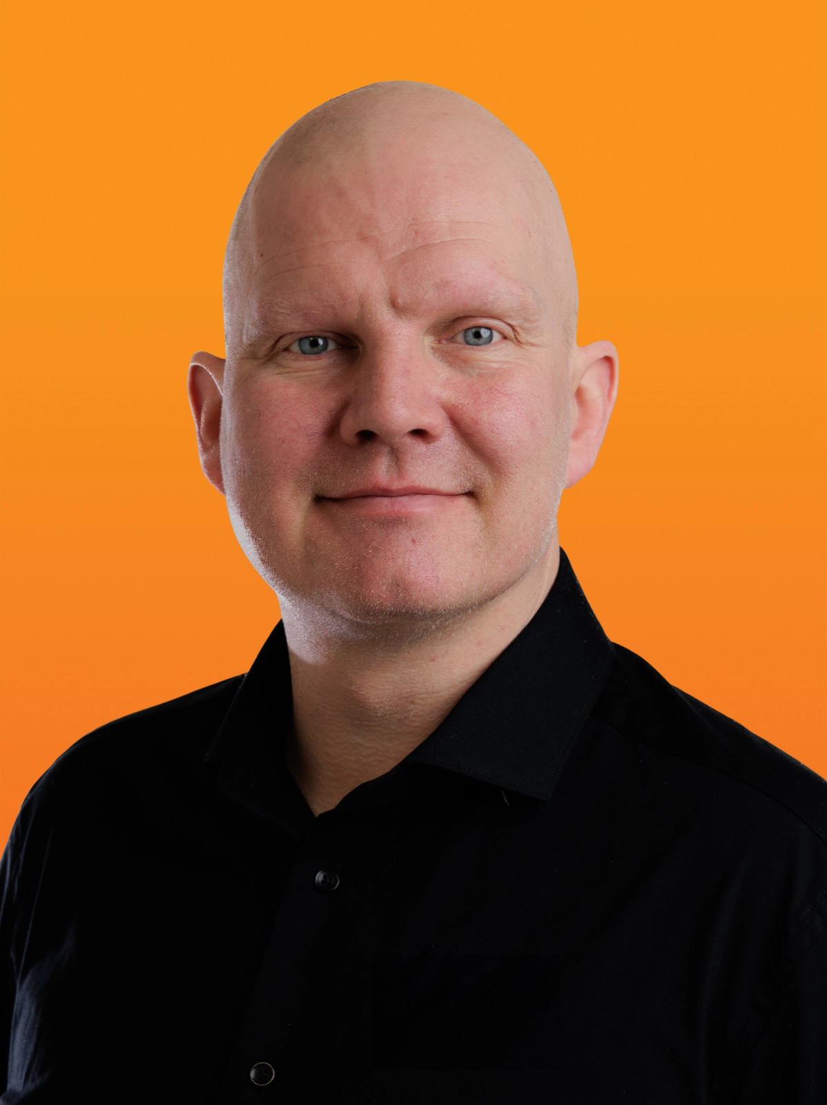 a bald man with blue eyes is wearing a black shirt