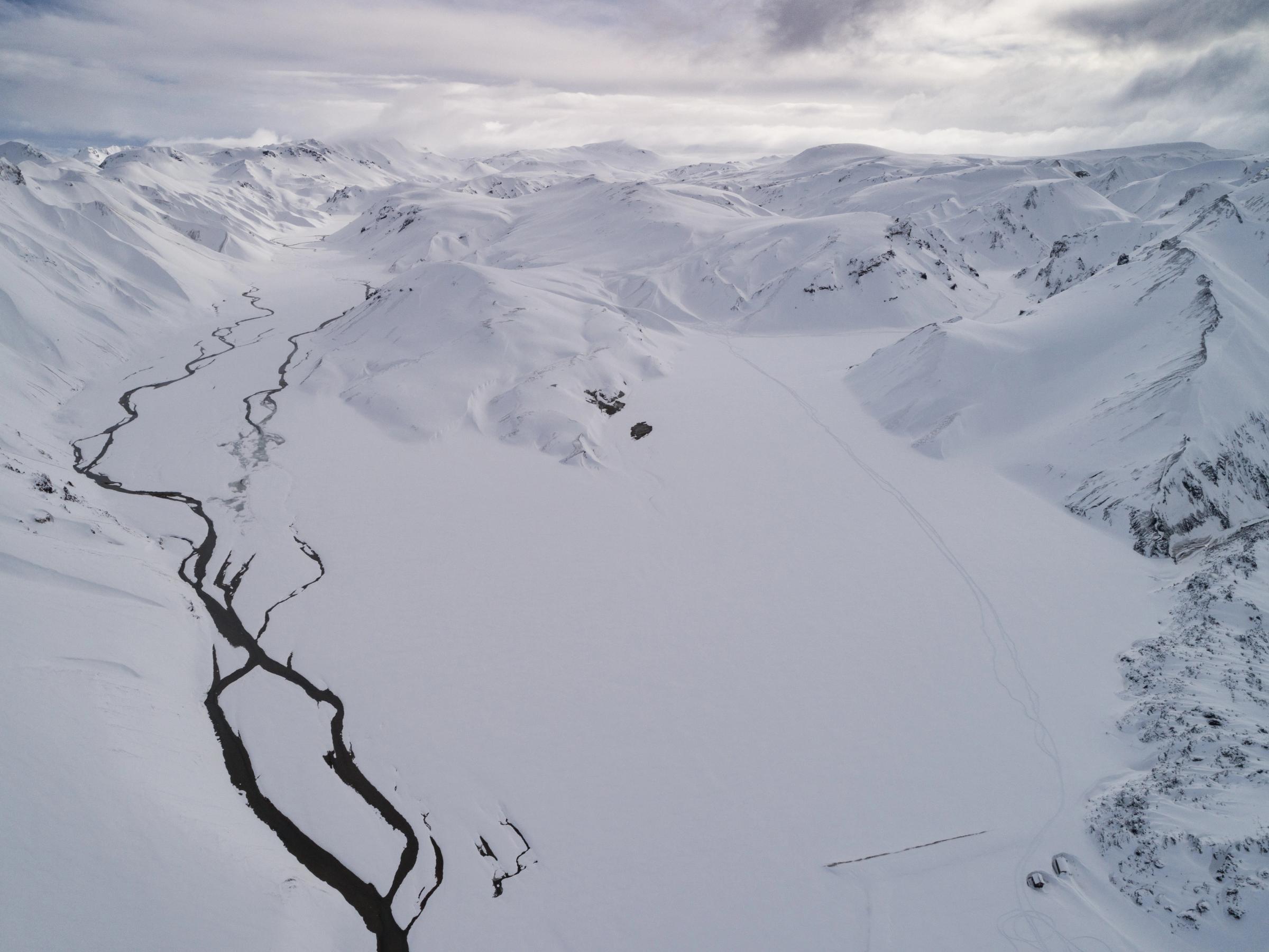 a landscape with a valley completely covered by snow