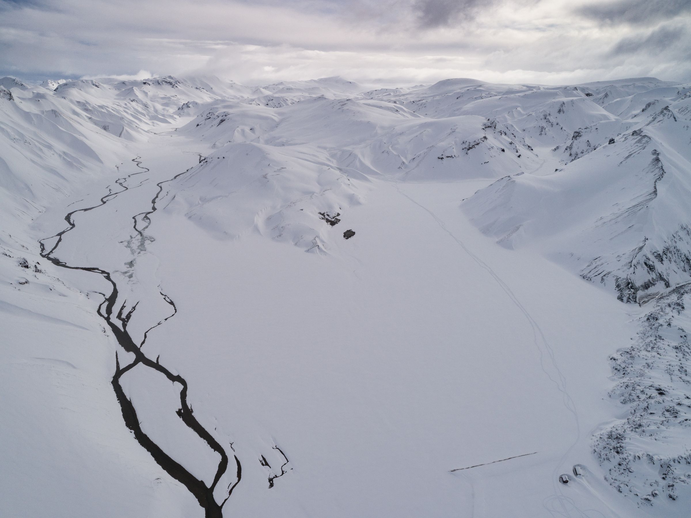 a landscape with a valley completely covered by snow