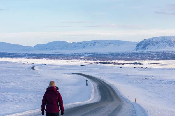 Femme marchant sur une route entièrement couverte de neige
