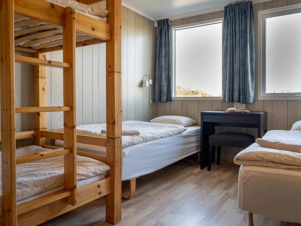 un dormitorio con literas, un escritorio y una ventana.