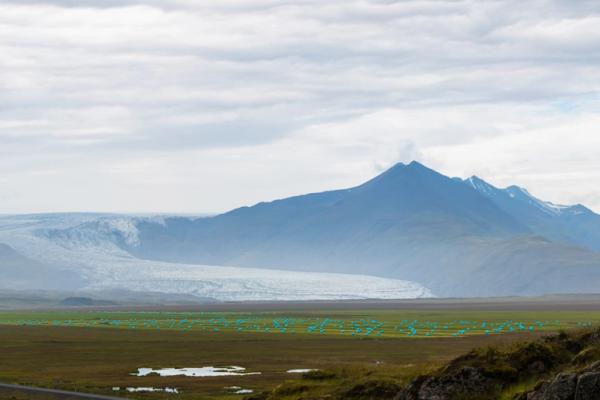 Man stretching his arms while on top of a rock with a stunning landscape behind him