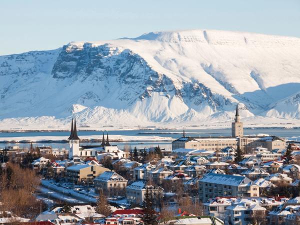 a coastal city covered by snow with a big mountain covered by snow in the background