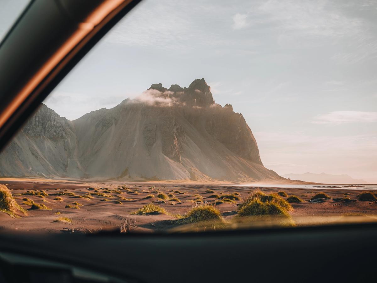 Vista de un paisaje desértico y una montaña desde dentro de un coche