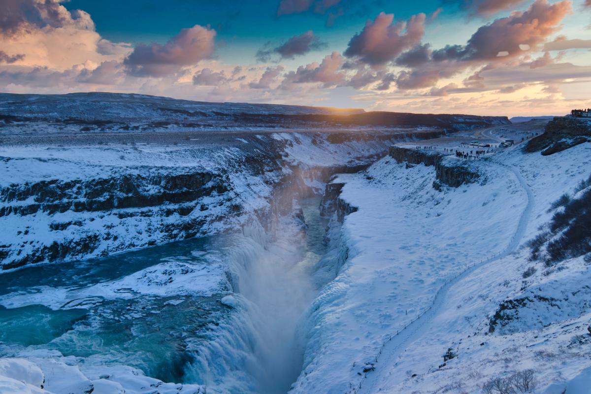 a waterfall in the middle of a snowy canyon at sunset at gullfoss in Iceland,