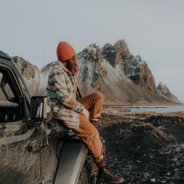 Chica sentada en su coche de alquiler en Islandia