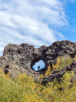 a person is standing in a hole in a rock formation at dimmuborgir in Myvatn are in iceland.