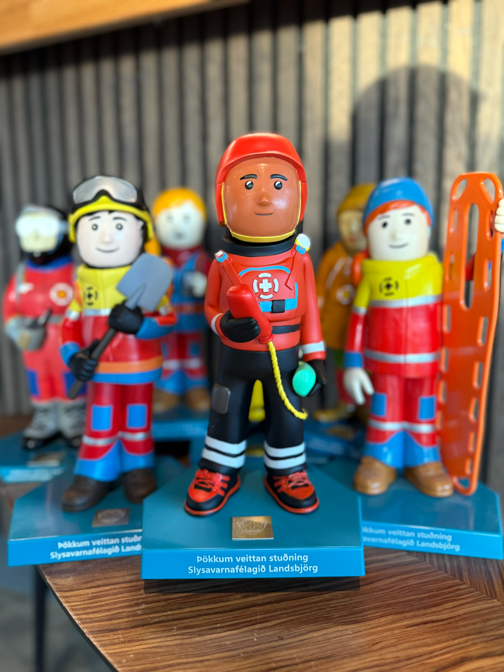 Colorful figurines depicting Icelandic Search and Rescue members, standing on blue bases.