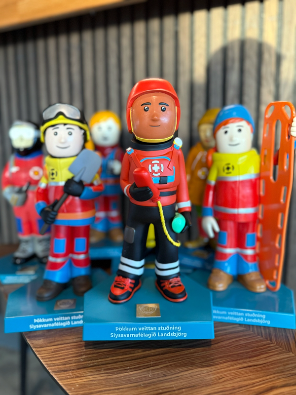 Colorful figurines depicting Icelandic Search and Rescue members, standing on blue bases.