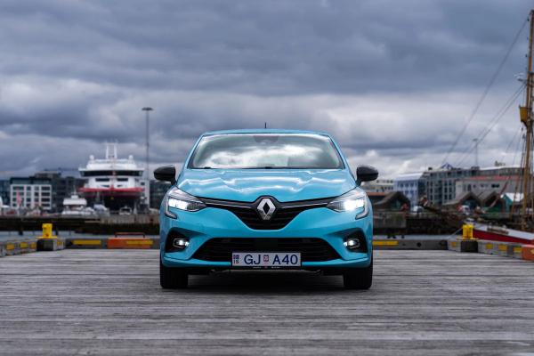 Blue Renault Clio parked on a wooden dock at a harbor under a cloudy sky.