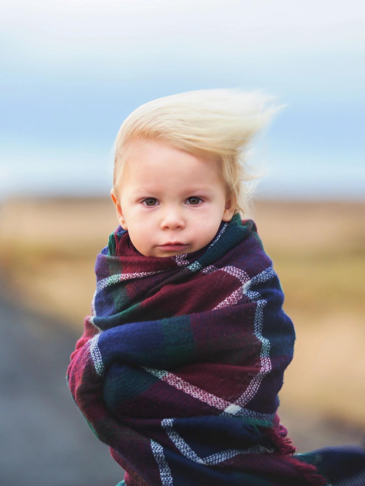 Kid standing in a road in Iceland on a very windy day