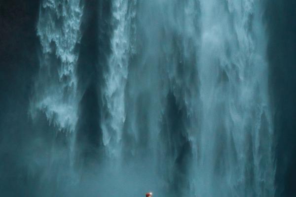 Waterfall iceand woman A woman standing next to a huge waterfall in iceland